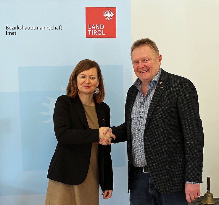 Bezirkshauptfrau Eva Loidhold und der neue Bürgermeister-Stellvertreter Hubert Fischer schütteln sich die Hände.