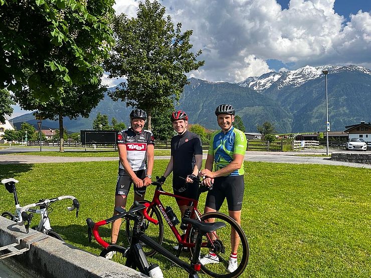 3 Rennradfahrer vor Trinkbrunnen