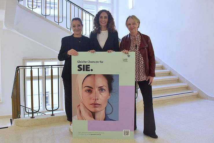 Personen halten großes Plakat (Kapaplatte) mit Sujet: dort sind zwei Gesichtshälften von Frauen zu sehen und der Claim "Gleiche Chancen für SIE."