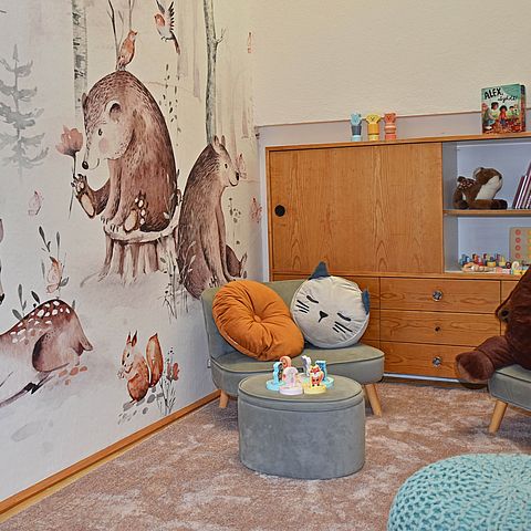 Ecke mit Tapete für Kinder (Waldtiere), Hocker, Spielsachen und Bücherregal
