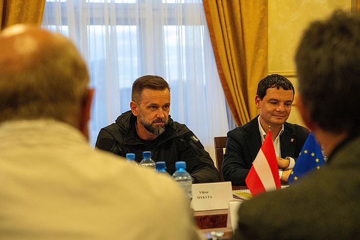 Gouverneur Viktor Mykyta (li.) und Regionalratspräsident Roman Saray sitzen an einem Tisch.