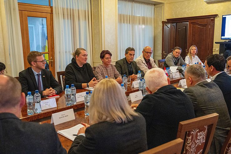 Die Tiroler Abordnung und VertreterInnen der transkarpatischen und des Regionalrats sitzen zu Gesprächen an einem Tisch