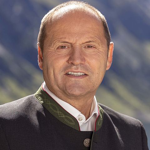 Brustbild von LHStv Josef Geisler, der eine dunkle Trachtenjacke mit grünem Kragen trägt.