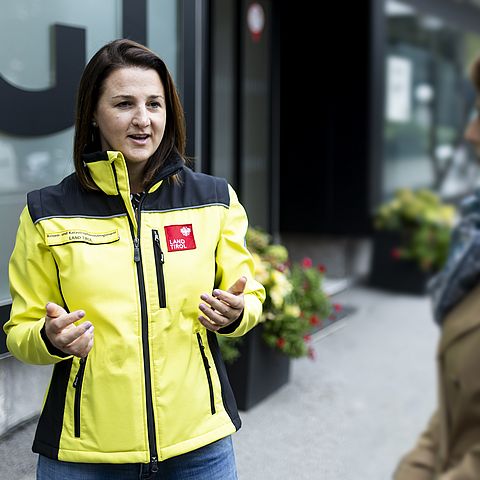LRin Mair mit Gelber Sicherheitsjacke sprechend