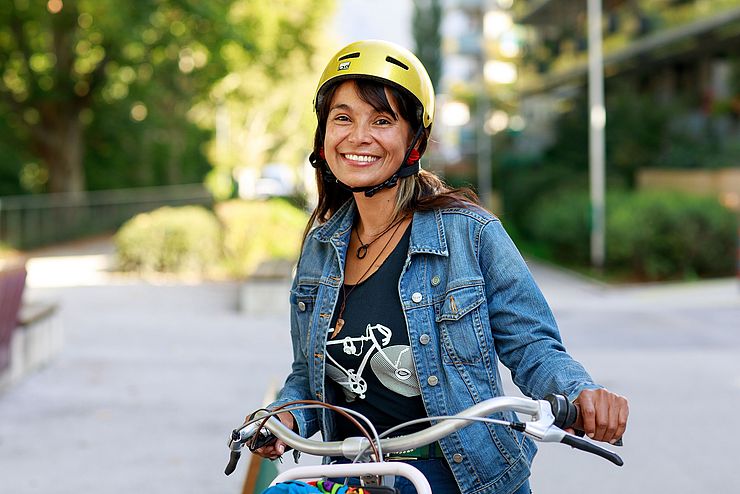 Eine junge Frau mit Helm und Fahrrad