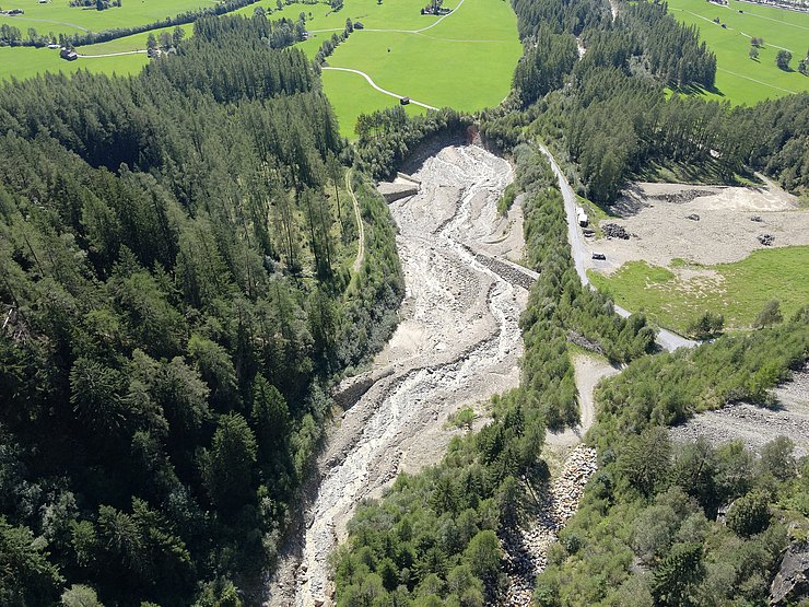 © Land Tirol/Drohnen-Einsatz-Gruppe Blick von oben auf bewaldeten Hang, der von Murrinne durchzogen ist.