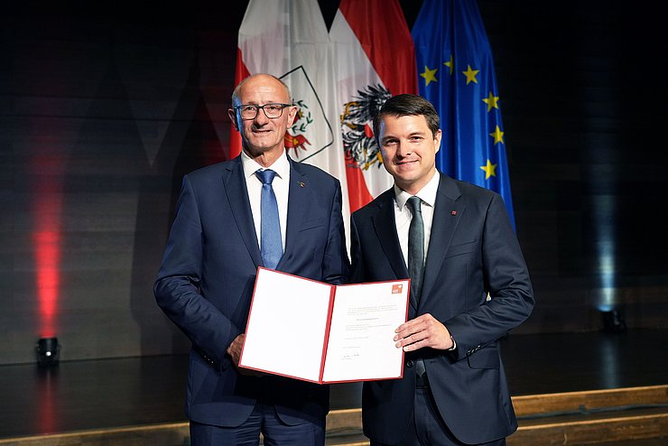 LH Mattle und BH Berek nebeneinander stehend mit Dekret in der Hand