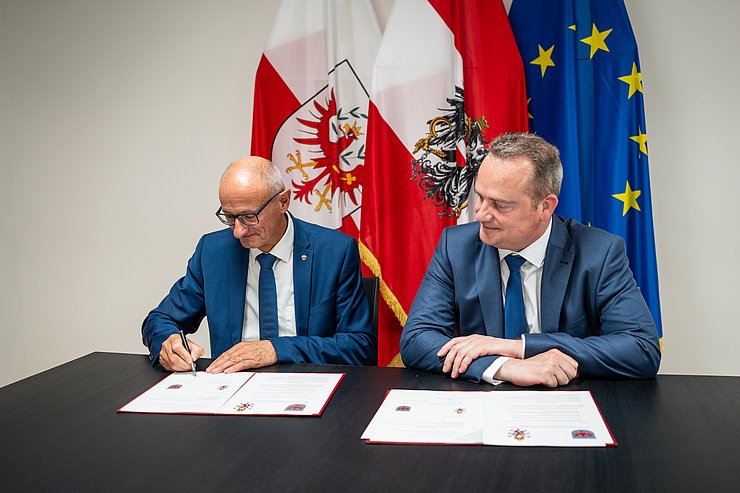 © Land Tirol/Fitsch Zwei Männer unterzeichnen ein Dokument