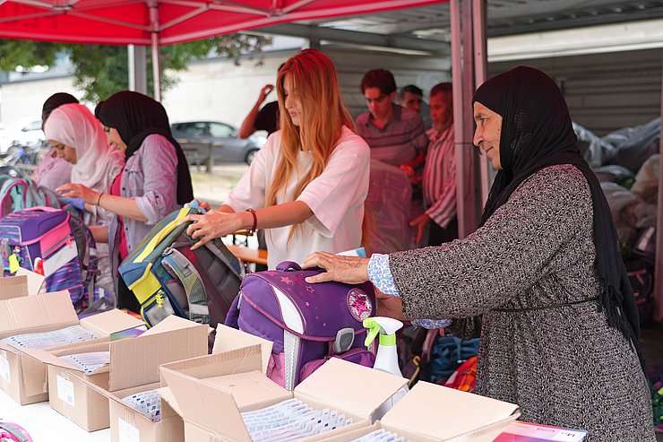 © Land Tirol/Dorfmann Frauen reinigen Schultaschen und befüllen sie