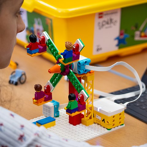 Ein Lego-Roboter vor einem Tablet.