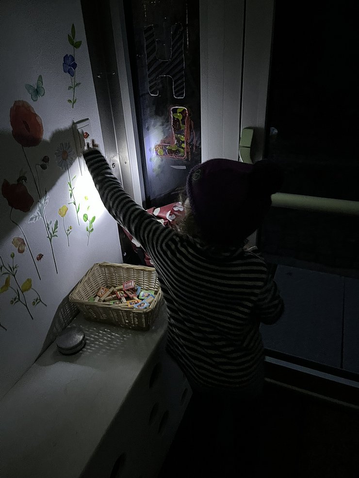 Kind im Dunkeln mit Taschenlampe
