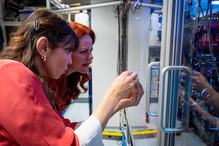 Hagele und Ferlaino schauen in einen Laborkasten.