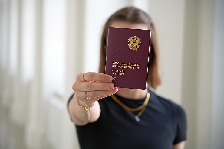 © Land Tirol/Schallhart Reisepass wird von einer Frau in die Kamera gehalten.
