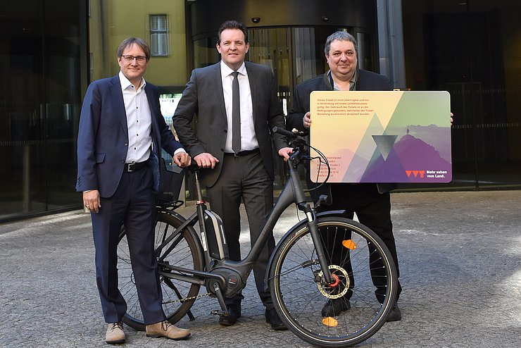 Gruppenfoto mit Fahrrad und großem Öffi-Ticket aus Karton