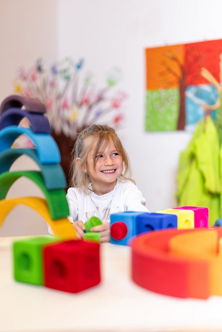 Lachendes Mädchen mit bunten Bausteinen
