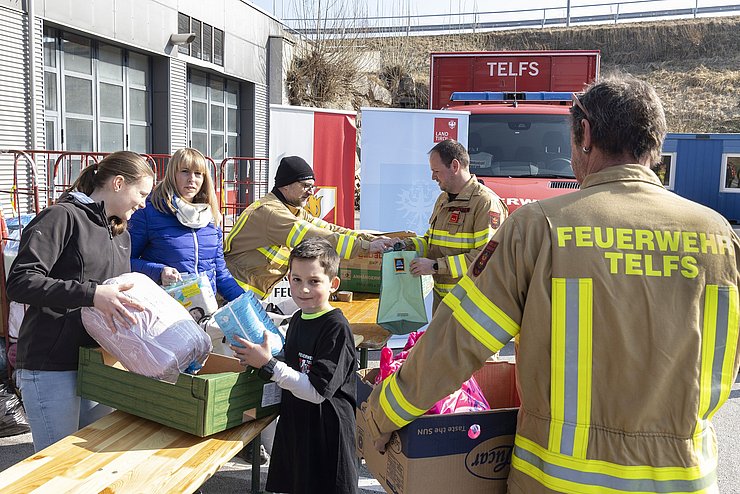 Feuerwehr und Menschen, die Güter annehmen.