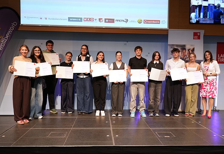 © Land Tirol/Trenker Jugendliche mit Urkunden und eine Frau auf der Bühne