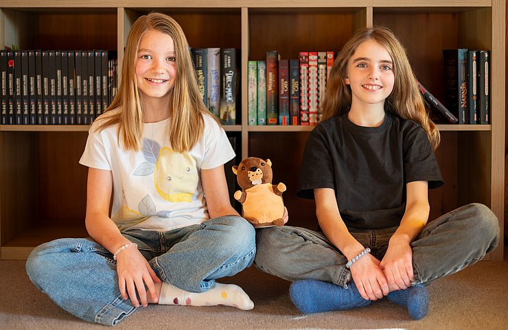 © Land Tirol Zwei Mädchen halten ein Murmeltierkuscheltier.