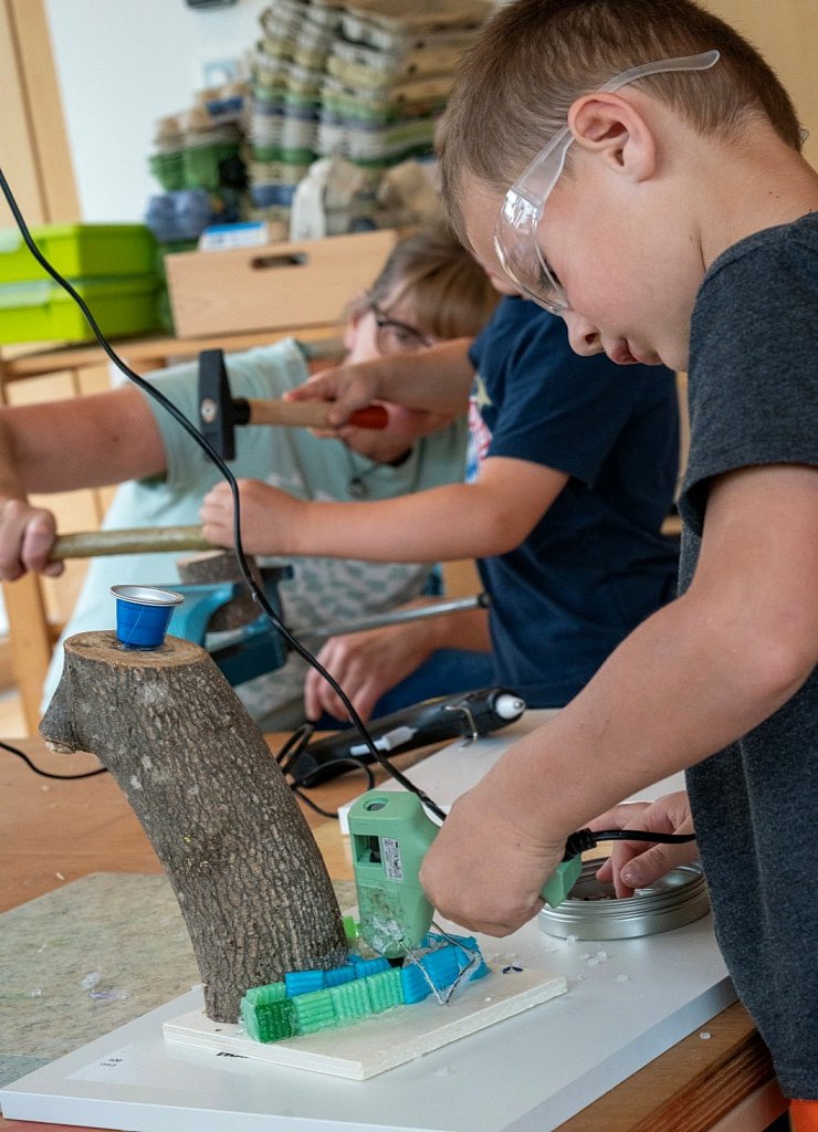Kind bastelt mit verschiedenen Materialien