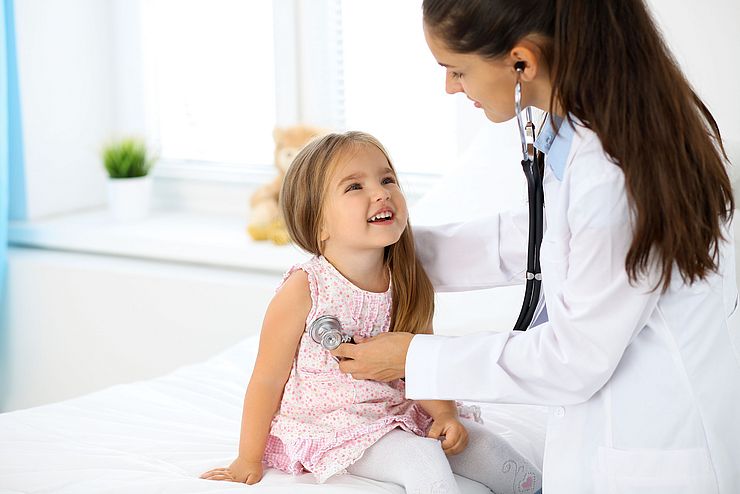 Kinderärztin untersucht kleines Mädchen mit Stethoskop