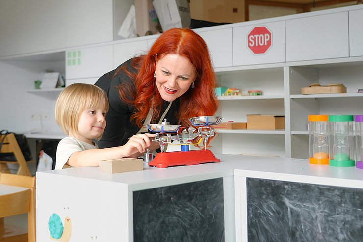 © Land Tirol/Trenker Hagele spielt mit einem Kind.