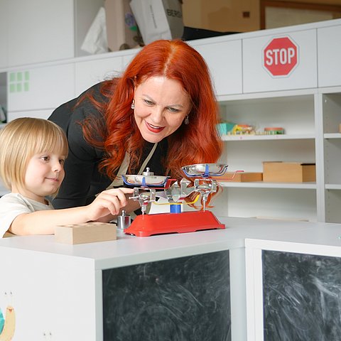 Hagele spielt mit einem Kind.