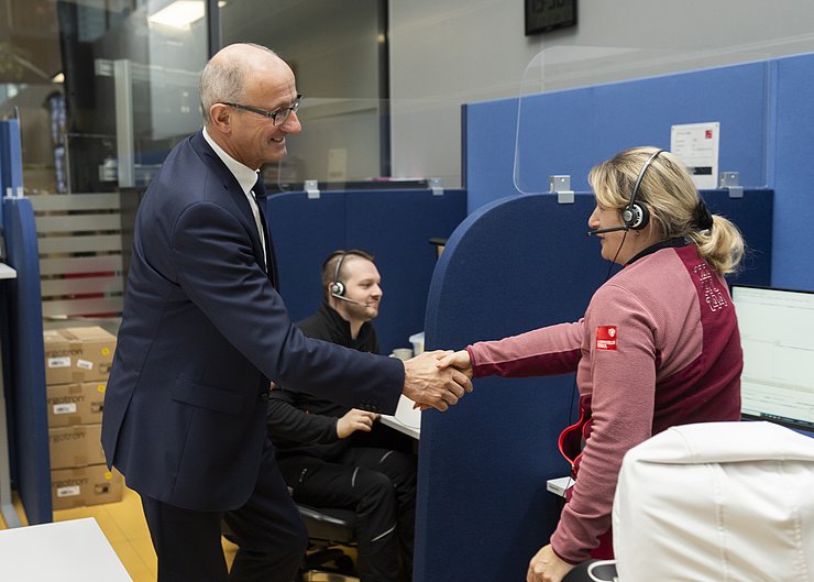 Foto von LH Anton Mattle, der einer Mitarbeiterin der Leitstelle Tirol die Hand schüttelt und sich bedankt