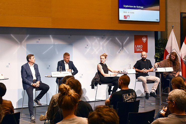 Die Podiumsgäste auf der Bühne, sitzend