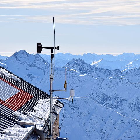 Die Windstation steht am Dach der Erzherzog-Johann-Hütte mit Bergen im Hintergrund.