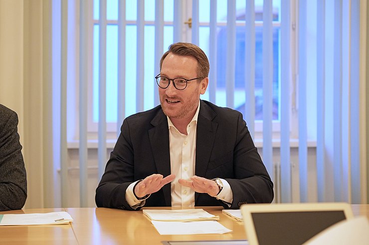 © Land Tirol/Reiter Wohlgemuth an Tisch sitzend und redend