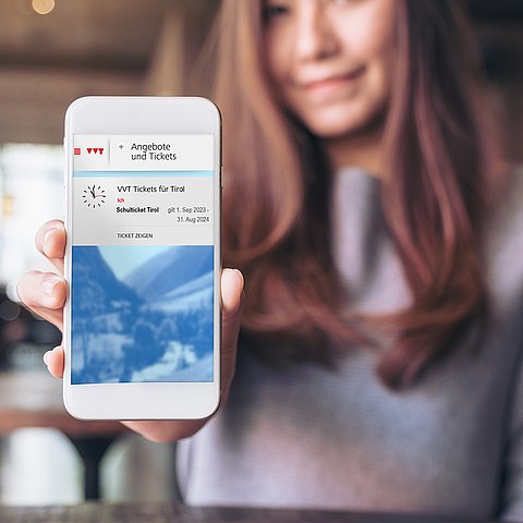 Mädchen hält digitales Ticket am Smartphone hoch