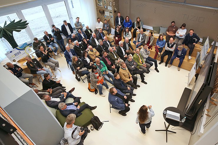 Raum mit Menschen; Frau hält Vortrag