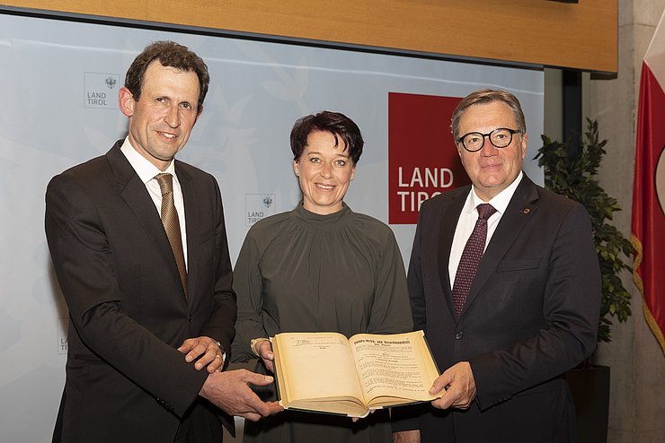 v.li.: Christoph Grabenwarter (Präsident des Österreichischen Verfassungsgerichtshofes), Landtagspräsidentin Sonja Ledl-Rossmann und LH Günther Platter mit dem Landesgesetz- und Verordnungsblatt, in dem die Landesordnung vor 100 Jahren verlautbart wurde. 