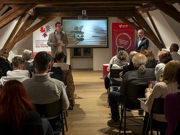 Raum mit Menschen - vorne wird auf Leinwand der Kalender gezeigt