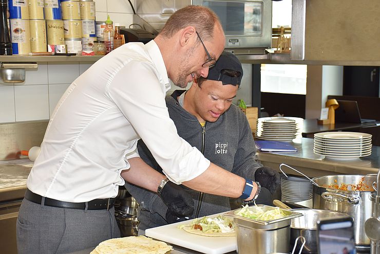 LR Gerber hilft Teilnehmer in der Küche