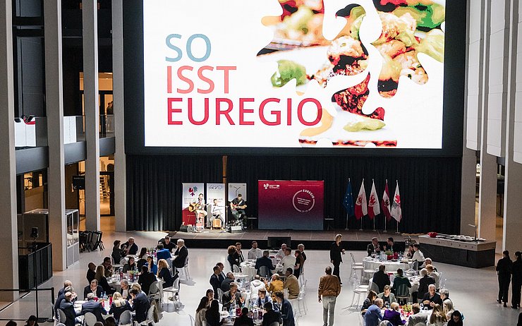Saal mit BesucherInnen und großer Leinwand
