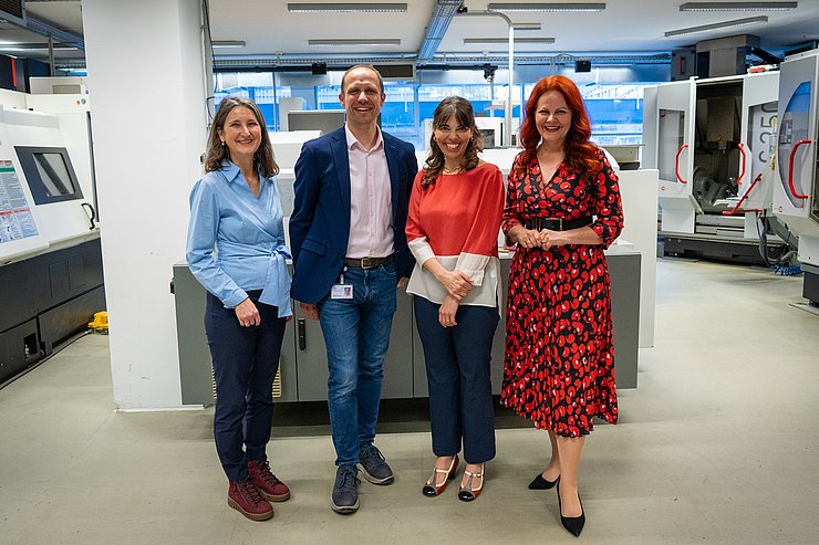 Gruppenaufnahme in einer Werkstatt.