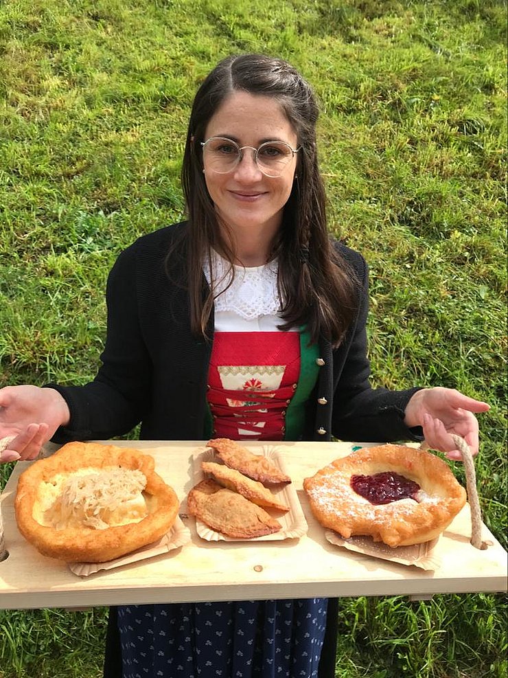 Frau hält Tableau mit Kiachln' und Krapfen