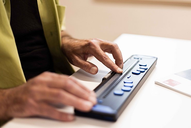 Braillezeile mit Händen