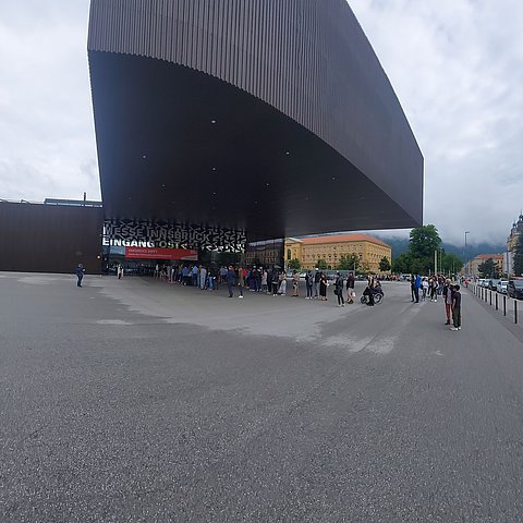 Messehalle in Innsbruck mit wartenden Menschen.