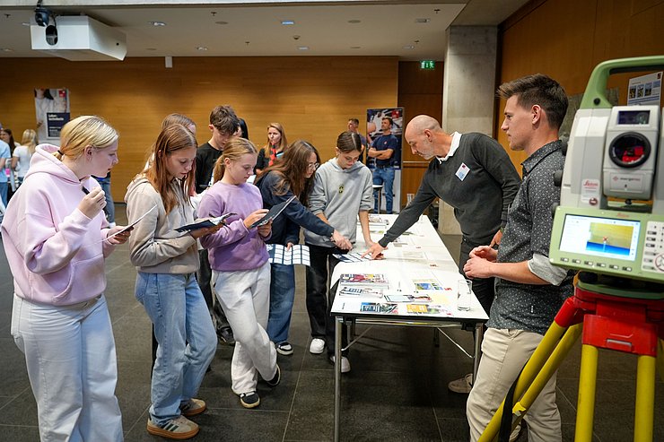© Land Tirol/Saxl Schülerinnen und Schüler informieren sich beim Messestand der Vermessungstechnik.