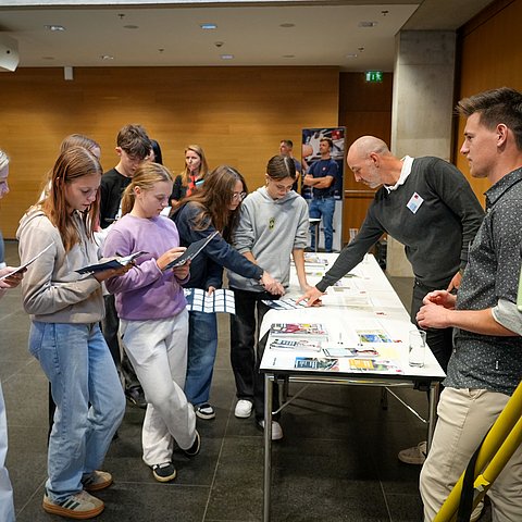 Schülerinnen und Schüler informieren sich beim Messestand der Vermessungstechnik.