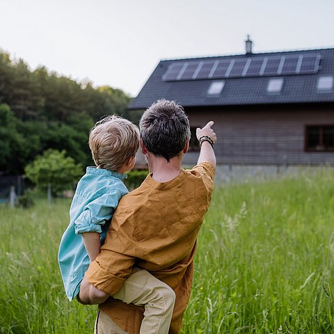 Vater und Sohn schauen auf ihr Haus