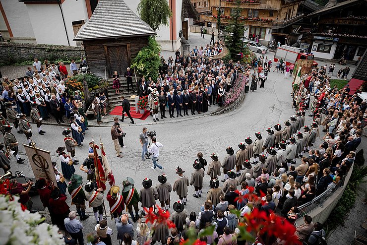 Kirchplatz Alpbach mit Schützen und Zusehern 