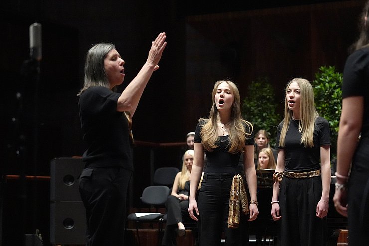 Mädchen singen, Frau dirigiert