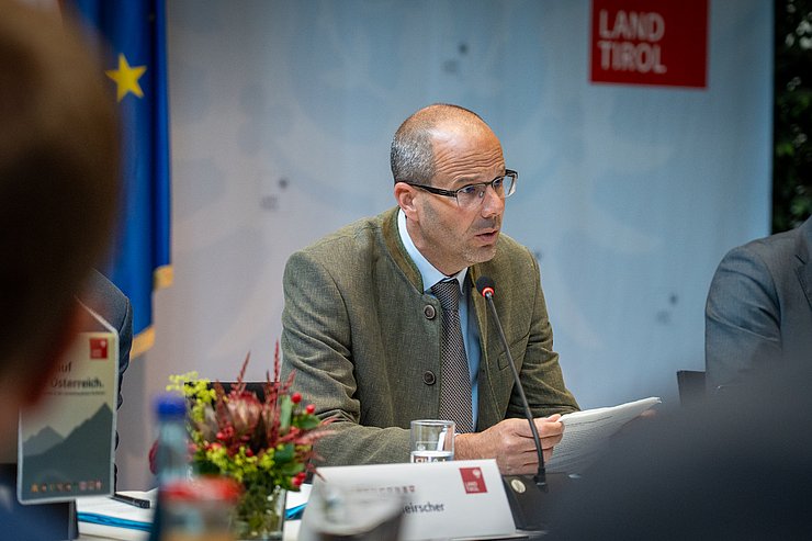 © Land Tirol/Neuner Nahaufnahme eines Mannes in grünem Sakko.