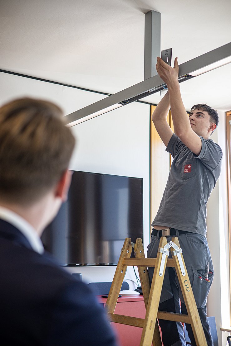 Mitarbeiter installiert LED Lampe auf Decke