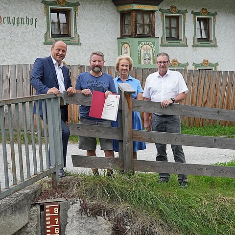 Vier Menschen sind bei einem Gruppenbild zu sehen.