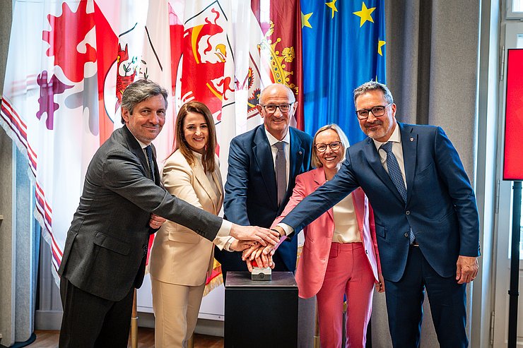 © Land Tirol/Fitsch Personen drücken auf großen roten Knopf
