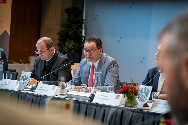 © Land Tirol/Neuner Bundeminister Totschnig sitzt an großer Tafel und redet